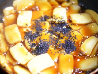 9、红糖年糕,撒上黑芝麻芝麻再次翻拌，使每一片年糕均匀裹上红糖和芝麻。