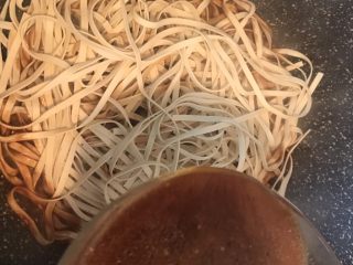 18、五花肉豆角焖面,将面条均匀地平铺在锅中并将之前盛出的汤汁均匀地浇在面上
