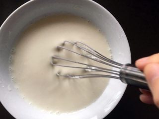 3、黄桃糯米糍,将糯米粉、白砂糖、玉米淀粉、牛奶混合。用打蛋器搅拌均匀，呈没有颗粒的糊状。