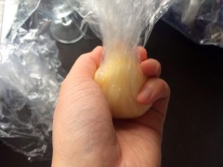 18、黄桃糯米糍,如图中所示，一只手握住底部，另一只手捏着上部收口。