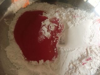 5、双色果蔬芋圆,趁热将煮好的火龙果皮汁倒入150克木薯粉中；