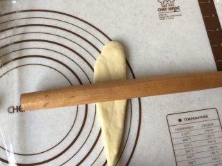 6、黄油卷,左手按住细的一端,右手拿擀面杖由下而上慢慢擀,再从上而下卷起来