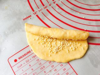 6、咸香芝麻饼,将饼皮由上往下卷起来，尽可能卷得紧凑一些。