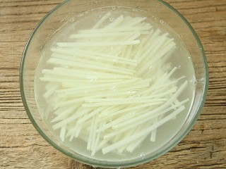 3、夏日小菜凉拌土豆丝,切好的土豆丝用清水浸泡,再重复浸泡清洗几次,主要是为了浸泡出土豆的淀粉,这样口感才更爽脆。