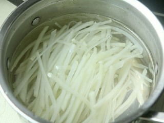 9、夏日小菜凉拌土豆丝,捞起土豆丝沥干水,放入凉白开内浸泡,几分钟后捞出控干水。