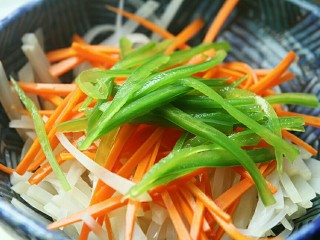 12、夏日小菜凉拌土豆丝,把土豆丝和胡萝卜丝和青椒丝放入碗内备用。