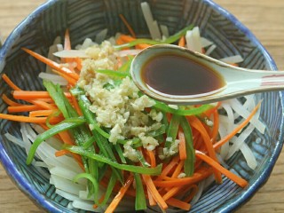 14、夏日小菜凉拌土豆丝,炒好的蒜蓉放入土豆丝内,倒入酱油 3匙。