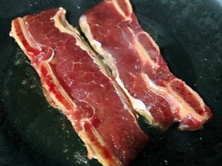 6、黑椒牛排意面,锅中倒入少许底油摆入牛排中火