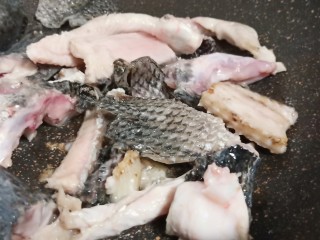 6、十味  记忆里的味道《酸菜鱼片面》,锅里加适量的油、放生姜片、蒜翻炒出香味、加鱼骨煎至两面微黄。