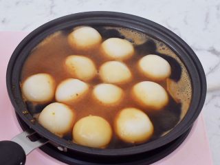 11、糖不甩,把煮熟的汤圆捞起，滤干，倒入红糖汁中，慢慢的中小火翻炒，让汤圆逐渐上色