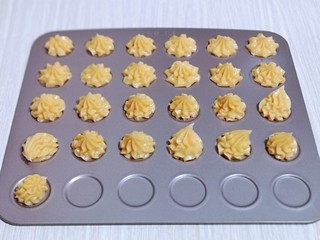 13、零失败~奶油泡芙 外酥内软吃出幸福甜蜜,挤入烤盘中即可,挤手法,手不要往下压,一边挤手一边提高。(不是不粘烤盘,记得垫上油纸)