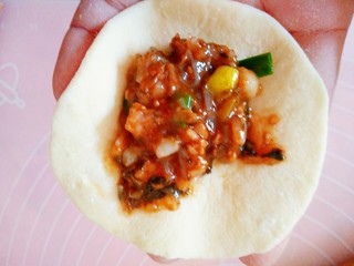 16、梅菜猪肉包,再把剂子擀成里面厚周边薄的面皮，再放上馅料
