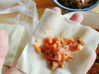 7、蒸云吞,拿出一张云吞皮，中间放上馅料