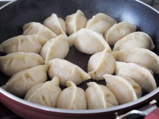11、十味 多汁猪肉煎饺,锅里稍微倒点油，烧热，然后将饺子码入，倒点水漫过饺子底面，盖上盖子，用中火煎， 8分钟左右水就收干了，底子也就焦黄香脆了，起锅享用。