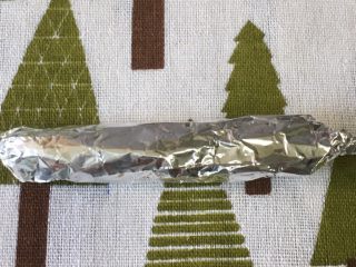 5、自制宝宝牛肉肠,把锡箔纸轻轻卷起来，卷的时候稍微压实一点。