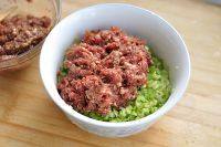 7、芹菜饺子,把腌渍好的猪肉馅、芹菜盛到干净盆里