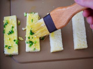 9、蒜香吐司条,再把刚才拌好的蒜葱拌料用毛刷刷到吐司条上