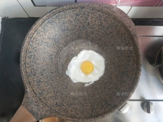 2、金枪鱼沙拉三明治,先煎一个水煎蛋。就是把鸡蛋先煎定型,然后加少量水。盖锅盖焖熟,是为了得到整个蛋黄,切面好看。