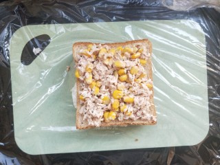 9、金枪鱼沙拉三明治,再放一片吐司。把金枪鱼沙拉铺上。