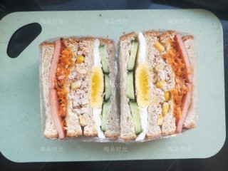 14、金枪鱼沙拉三明治,用锯齿面包刀从中间切开。