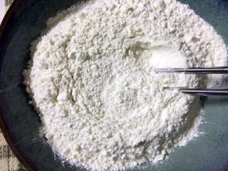 2、外脆内软的黑芝麻饼,用筷子当中扒开一点