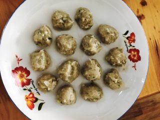 15、虾肉丸子,搅拌均匀后，用勺子将虾泥做成丸子放进盘子里摆放好。盘子要用水打湿，不然虾泥会粘盘子，另外准备一碗水，将勺子打湿，不然虾泥也会粘勺子，每做成一个丸子，都要把勺子放水里过一下，避免虾泥粘勺子。