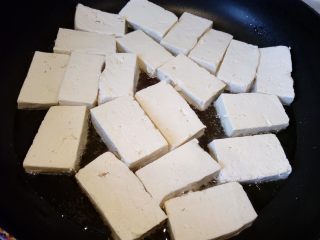 5、菌茹烩豆腐,锅内倒油，慢慢放入豆腐，不要叠放。