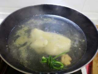 3、白切鸡,适量姜拍破或切片,小葱挽成结,连同鸡一起放入水里浸煮,大火烧开后改中小火煮15分钟后关火焖10分钟。(如果鸡大可以多煮几分钟,但不宜煮太久,鸡肉会煮老,关火后焖可以让鸡肉利用水的余温确保熟透。)