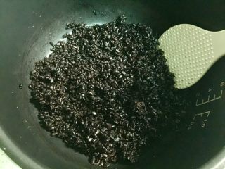 2、黄金黑米卷,在黑米饭里加一些盐和胡椒粉调味，拌匀。