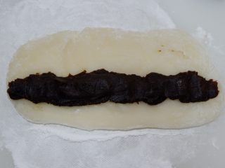 12、枣泥糯米卷,将枣泥馅搓成长条。放在擀好的面片上