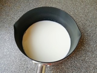 1、草莓蛋挞,纯牛奶倒入小锅里,加入白砂糖,开最小火加热,搅动至白砂糖完全融化关火。