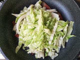 6、腊肉包菜锅巴饭,下入包菜丝。