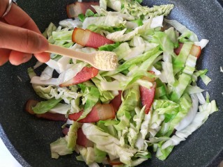 7、腊肉包菜锅巴饭,翻炒至包菜变色后加入适量的盐和鸡精。