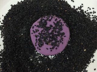 15、烤紫薯糯米饼,将饼坯放在芝麻上，两边都均匀的沾上芝麻