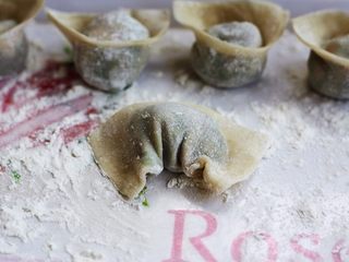 9、荠菜鸡肉馄饨,如图，把两个角弯过来，然后捏在一起。