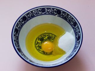 3、酥得掉渣的芝麻桃酥,首先取一大口碗，把花生油、鸡蛋、甘汁园双碳白砂糖放入碗中。