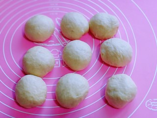 8、超级松软零失败的全麦蜜豆小餐包,发酵好的面团分成9等份。，盖上保鲜膜松弛20分钟。