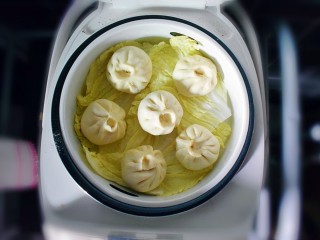 24、麻辣豆腐粉条香菇包,放在蒸锅上，凉水开始蒸。我没有用笼布，为了防粘，垫了一层白菜叶子，也可以在包子底下抹一层油防粘哦，根据自己习惯来。