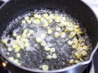 4、午餐肉饭团,将玉米掰成一粒粒洗净,胡萝卜控成丝,锅中烧开水,放入玉米焯熟捞出控干水分备用