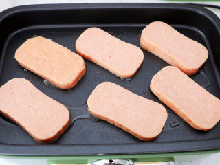 5、午餐肉饭团,午餐肉切成6片,锅中放少许食用油,放入午餐肉