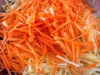 4、土豆胡萝卜抱蛋,土豆丝清洗掉多余的淀粉沥干水份和胡萝卜丝放入容器中