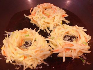 8、土豆胡萝卜抱蛋,锅中倒入半勺油加热土豆胡萝卜糊握成一个球状放锅中在中间隔离出一个小洞