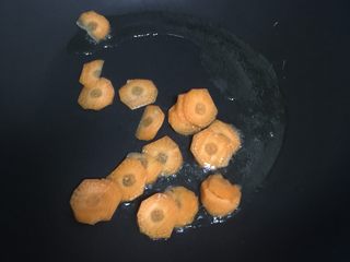 3、瘦肉玉米蔬菜粥,放入胡萝卜翻炒两下。