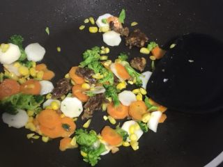7、瘦肉玉米蔬菜粥,把腌制好的肉沫倒入锅内划散，继续翻炒。