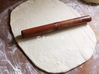 6、豆沙白玉卷,案板上撒上干粉，发酵好的面团倒上去揉透，然后用擀面杖擀成一张长方形的面片。