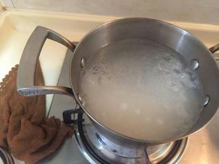 2、超鲜虾鱼片粥,放一锅水，小火慢慢炖煮。