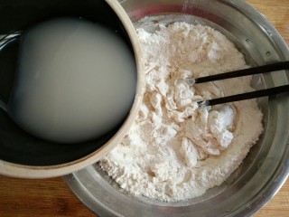 3、古早味麻酱红糖花卷&椒盐葱香花卷,然后少量多次加进面粉中，并用筷子将面粉搅拌成雪花状。