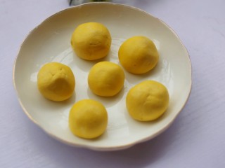 10、南瓜小橘灯,将面团分成6份揉成圆球，放入垫好油纸的盘中。