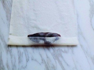 6、炸春卷,将春卷皮的一端卷起来，如图。