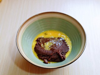 8、巧克力奶油泡芙,鸡蛋敲碗里,用筷子打散,将蛋液分三次倒入面团中,每加入一次蛋液后,“必须翻拌均匀,蛋液与面团完全融合在一起” 再加入蛋液,切记分三次加入蛋液,每次一定要拌均匀。